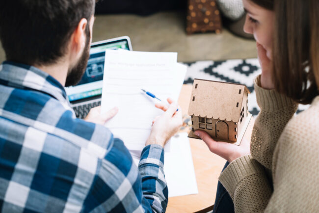 from-couple-with-mortgage-agreement Homebuyers comparing their mortgage rate quotes with a lender