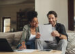 Home buyers reviewing documents to qualify for a mortgage on a new construction home