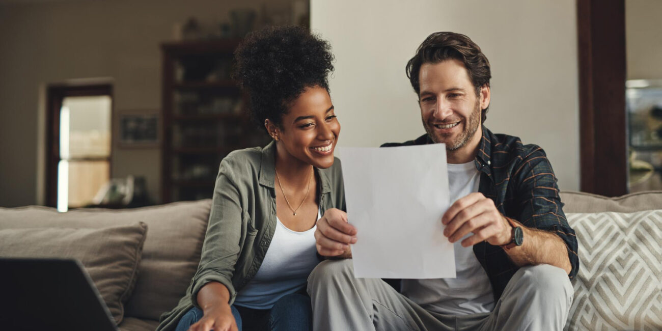 428505 Home buyers reviewing documents to qualify for a mortgage on a new construction home