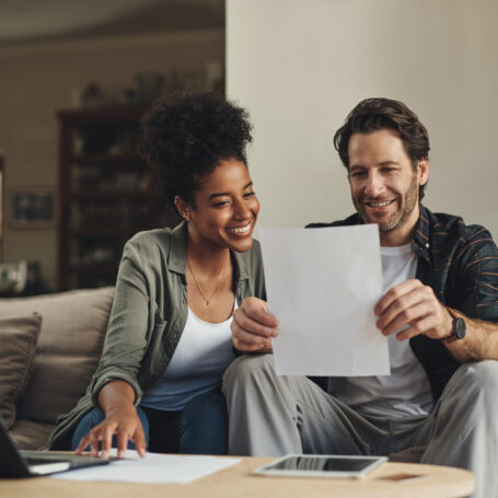 Home buyers reviewing documents to qualify for a mortgage on a new construction home