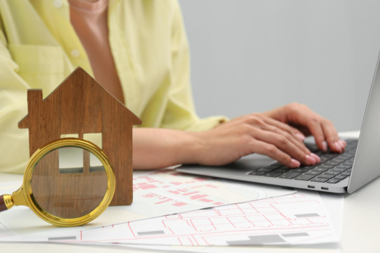 image-house-hunting-woman-with-laptop-papers-magnifying-glass-house-figure-white-table-closeup Buyers getting pre-approved before house hunting