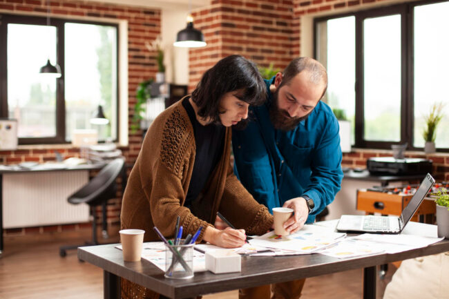image-homebuying-timeline-from-saving Professionals reviewing homebuying timeline from saving strategy and planning documents